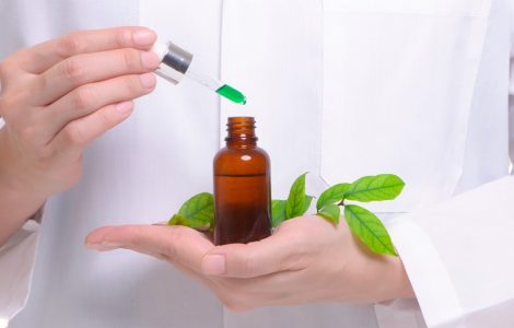 Médico com medicamento fitoterápico em mãos, o mostrando de forma centralizada.