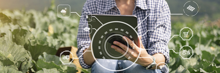 Pessoa segurando tablet em campo agrícola, com gráficos e ícones digitais sobrepostos na imagem