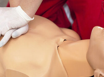 Profissional de primeiros socorros pratica ressuscitação cardiopulmonar em um boneco