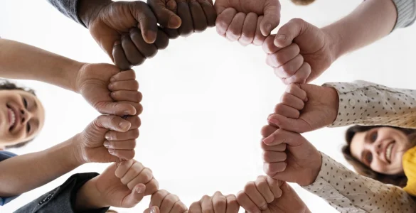 Imagem de mãos diversas unidas em um círculo, simbolizando igualdade e direitos humanos.