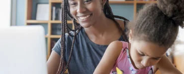 Profissional auxiliando uma paciente criança em ambiente clínico por meio de terapia ABA.