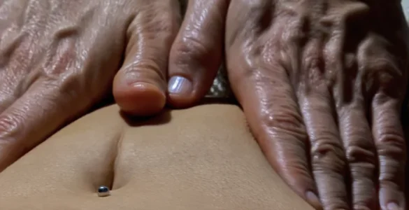 Massoterapeuta realizando massagem abdominal em pessoa deitada com toalha, em ambiente de spa.