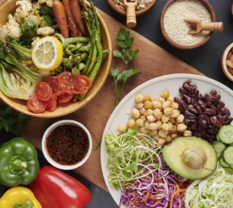 Prato colorido com legumes grelhados, grãos, sementes, castanhas e vegetais frescos em fundo escuro.