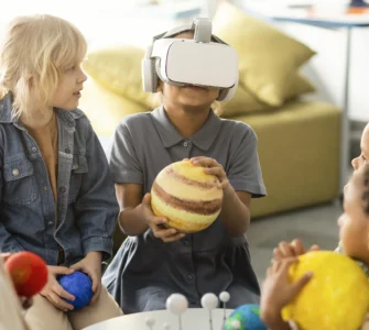 Crianças exploram o sistema solar com realidade virtual e modelos de planetas em sala de aula.
