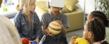 Crianças exploram o sistema solar com realidade virtual e modelos de planetas em sala de aula.