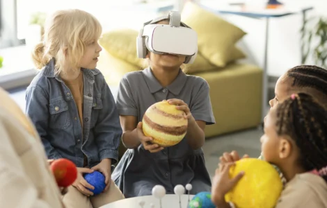 Crianças exploram o sistema solar com realidade virtual e modelos de planetas em sala de aula.