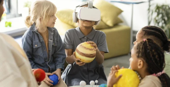 Crianças exploram o sistema solar com realidade virtual e modelos de planetas em sala de aula.