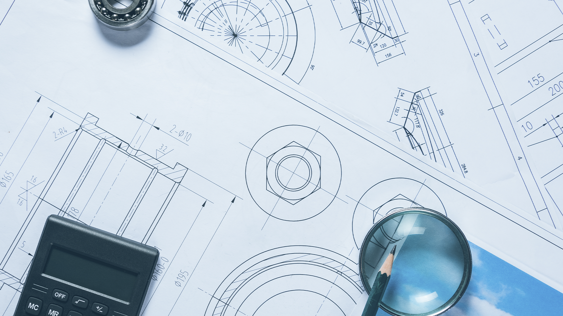 Desenhos técnicos com medições detalhadas, acompanhados de calculadora, lupa, rolamento e lápis.