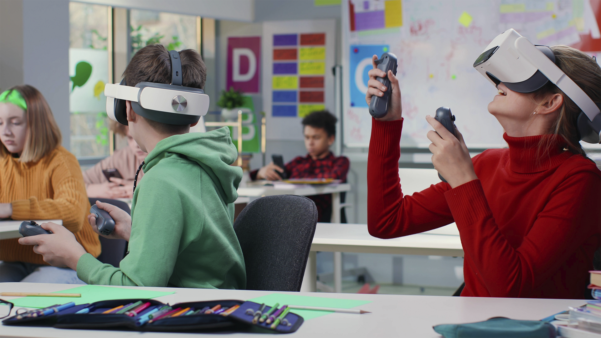 Alunos usam óculos de realidade virtual e controles em sala de aula para uma experiência educacional imersiva.