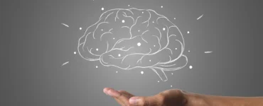 Mão sustentando um cérebro desenhado com conexões, simbolizando inteligência ou neuromarketing.