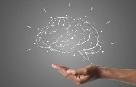 Mão sustentando um cérebro desenhado com conexões, simbolizando inteligência ou neuromarketing.