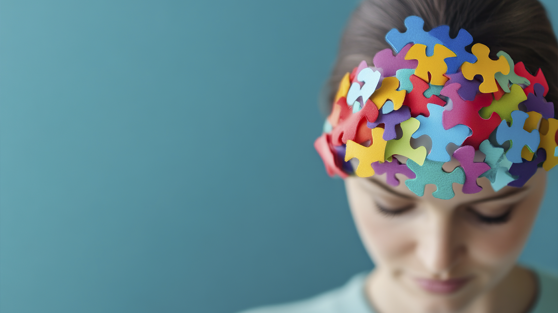 Mulher com peças de quebra-cabeça coloridas na cabeça, simbolizando mente, psicologia e complexidade dos pensamentos.