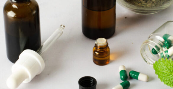 Frascos com extratos naturais, cápsulas verdes e folhas secas ilustrando o uso de fitoterapia personalizada.