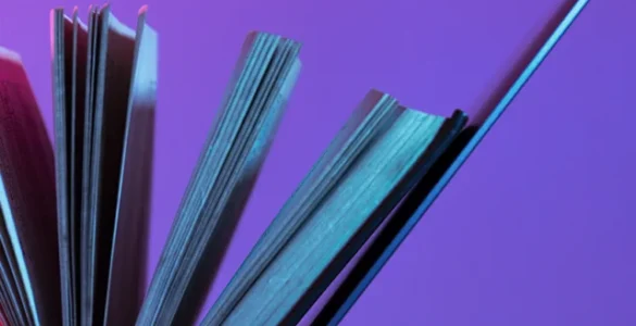 Livro aberto apoiado em um laptop, simbolizando a integração entre educação tradicional e tecnologia.