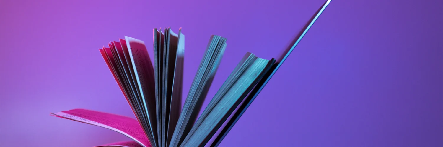 Livro aberto apoiado em um laptop, simbolizando a integração entre educação tradicional e tecnologia.