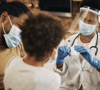 Profissional de saúde administrando vacina em paciente com máscara na clínica, destacando cuidados contra doenças.