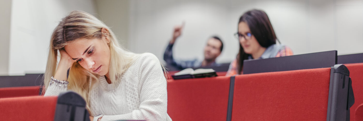 Estudante desanimada representando a evasão no ensino superior.