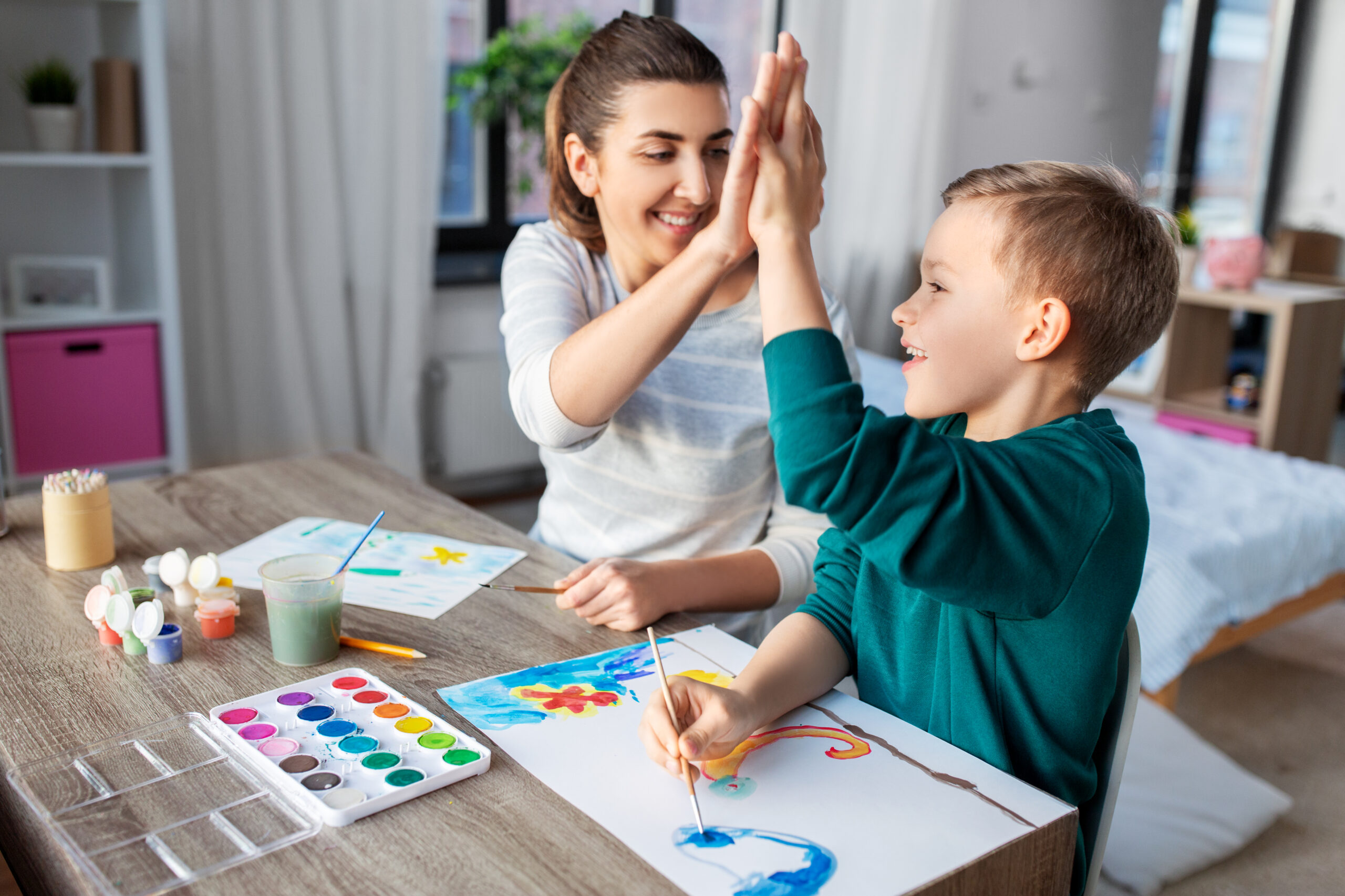 mother and son with colors drawing at home